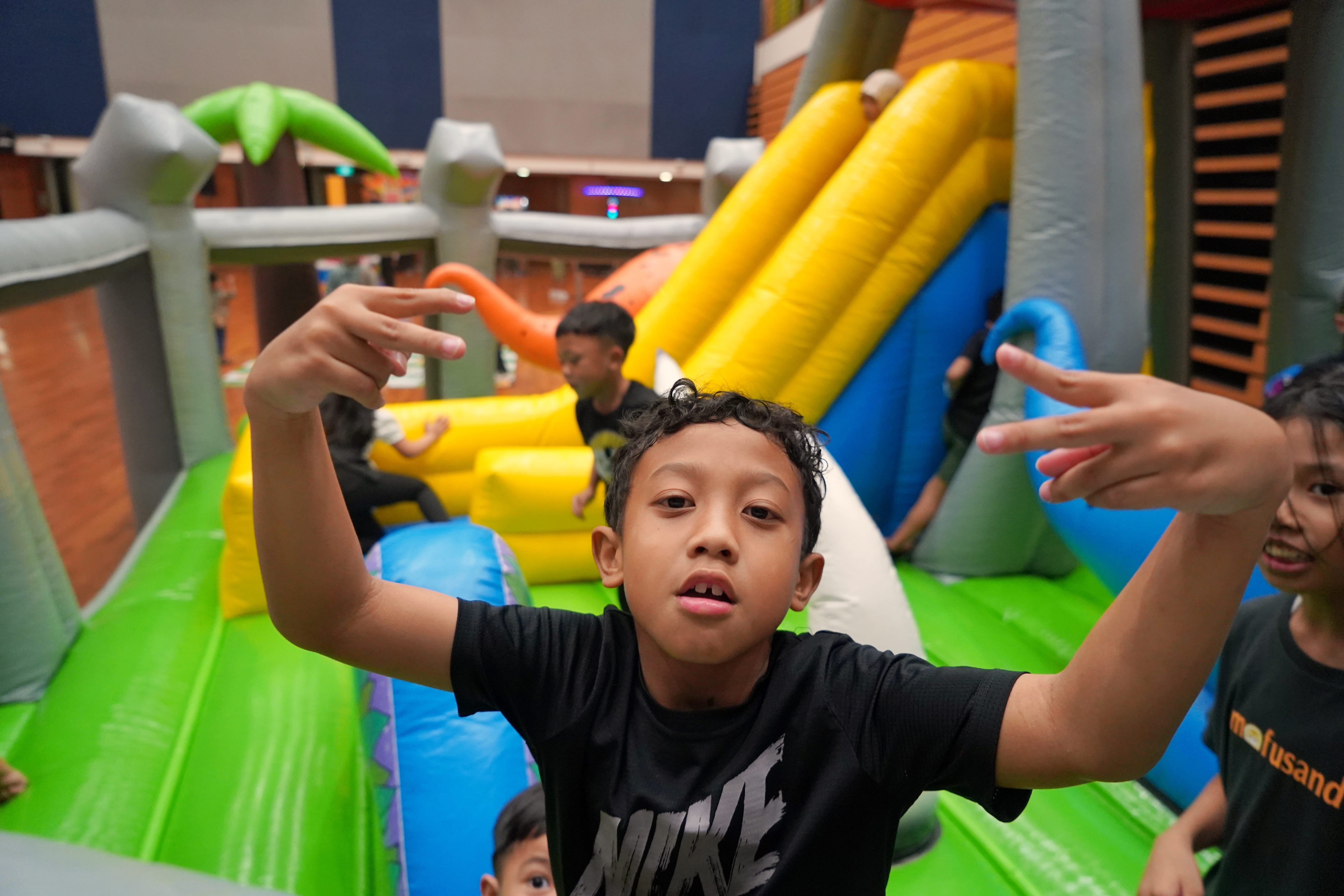 Children climb and play inside an inflatable playground set up.